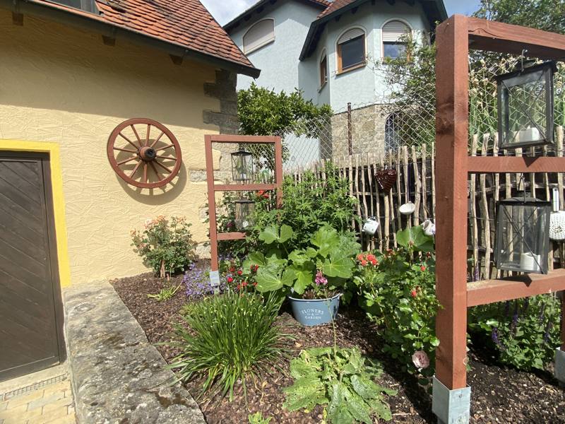 Sonniger Innenhof mit Blumen und Sitzplatz
